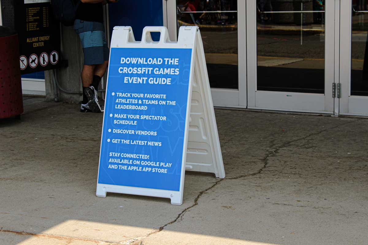 White A-Frame signage with a handle on the top, displaying a blue sign with rules and regulations for event guests.