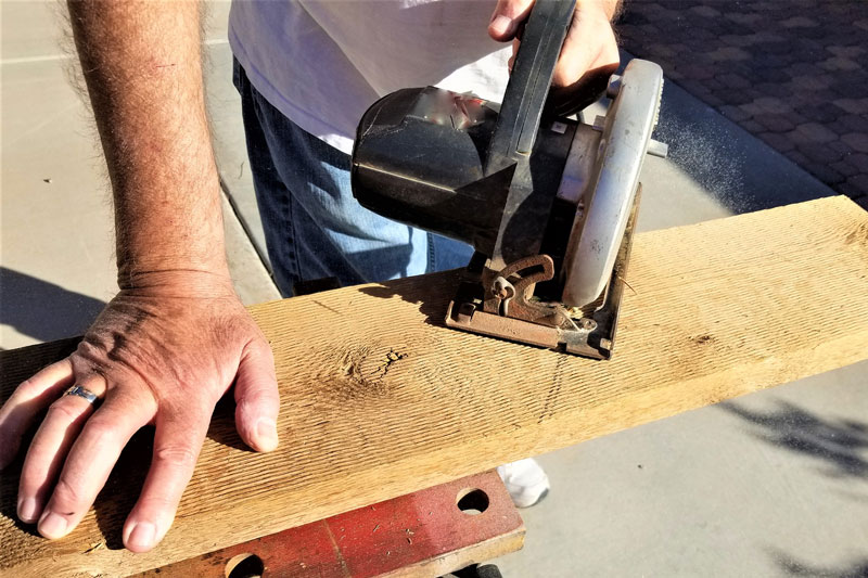 Close-up of a man using a jig saw to cut wood