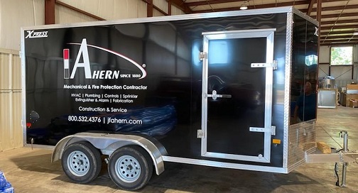 A black trailer displaying custom graphics.