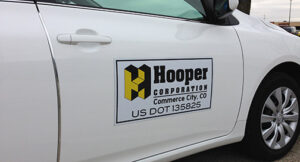 A white truck in a garage showing a decal on the driver's door.